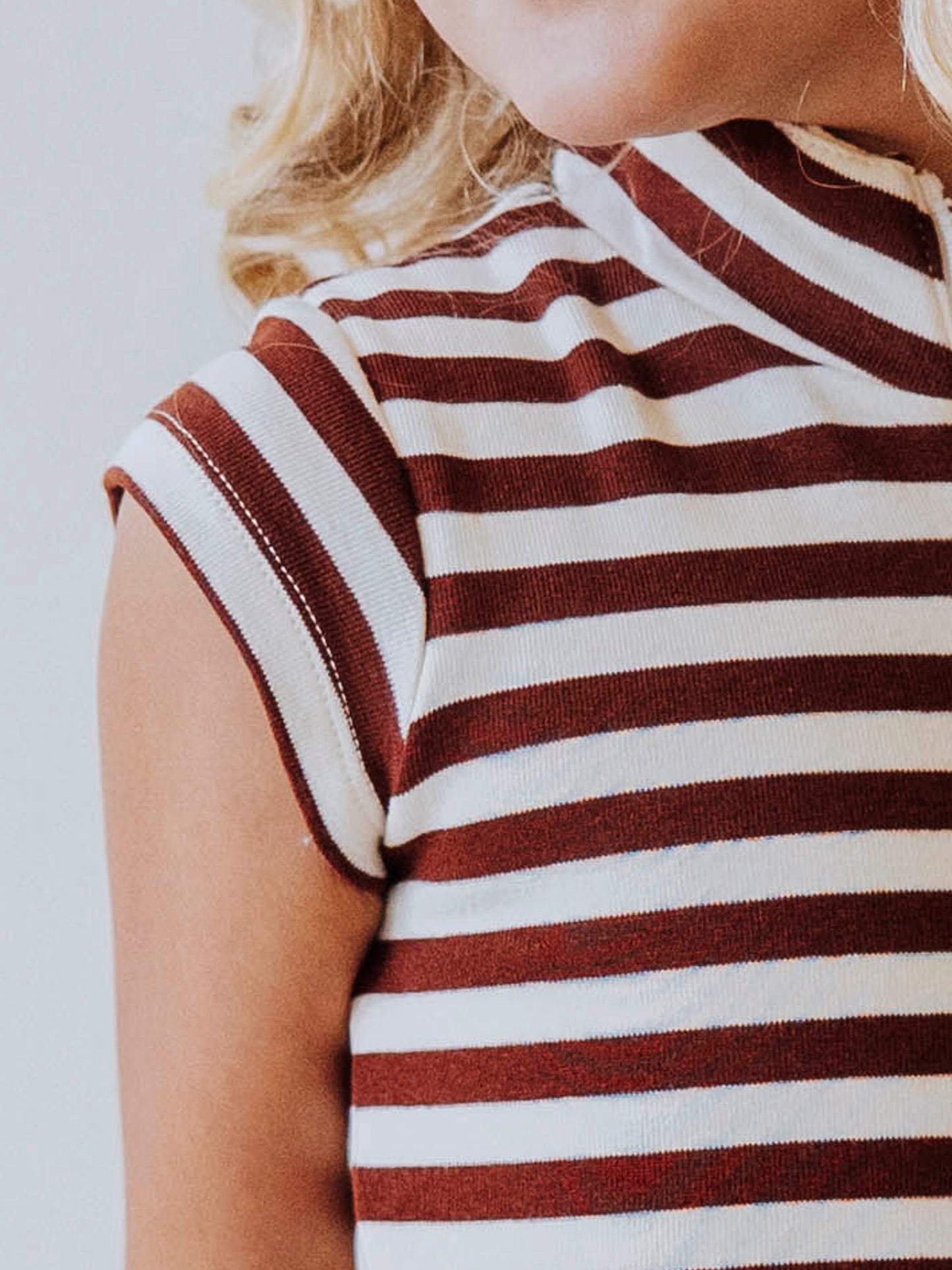 Up close picture of the cap sleeve on a brown and ivory striped dress. 