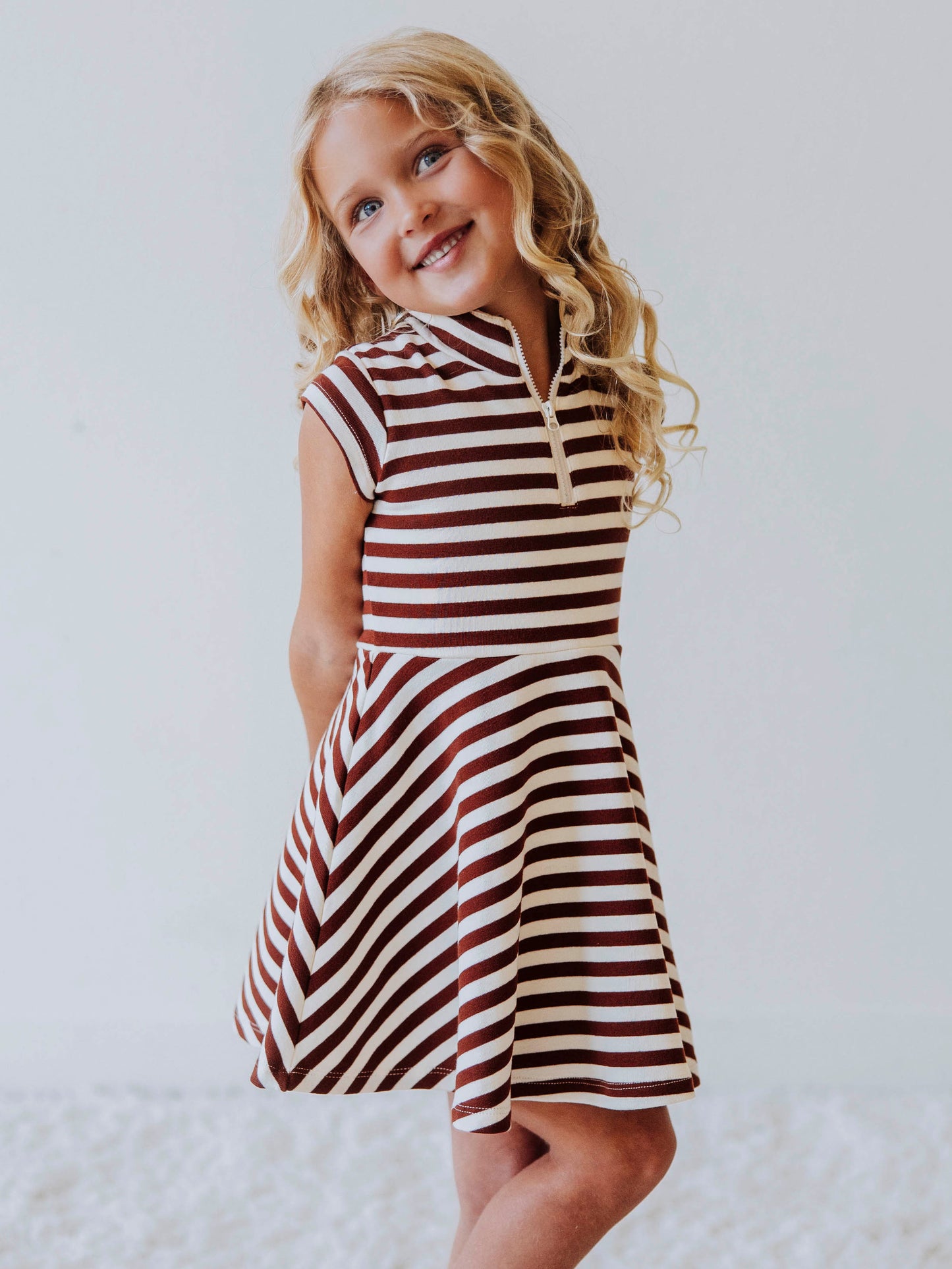 Model wearing a brown and ivory striped dress. Model is wearing brown shoes too. 