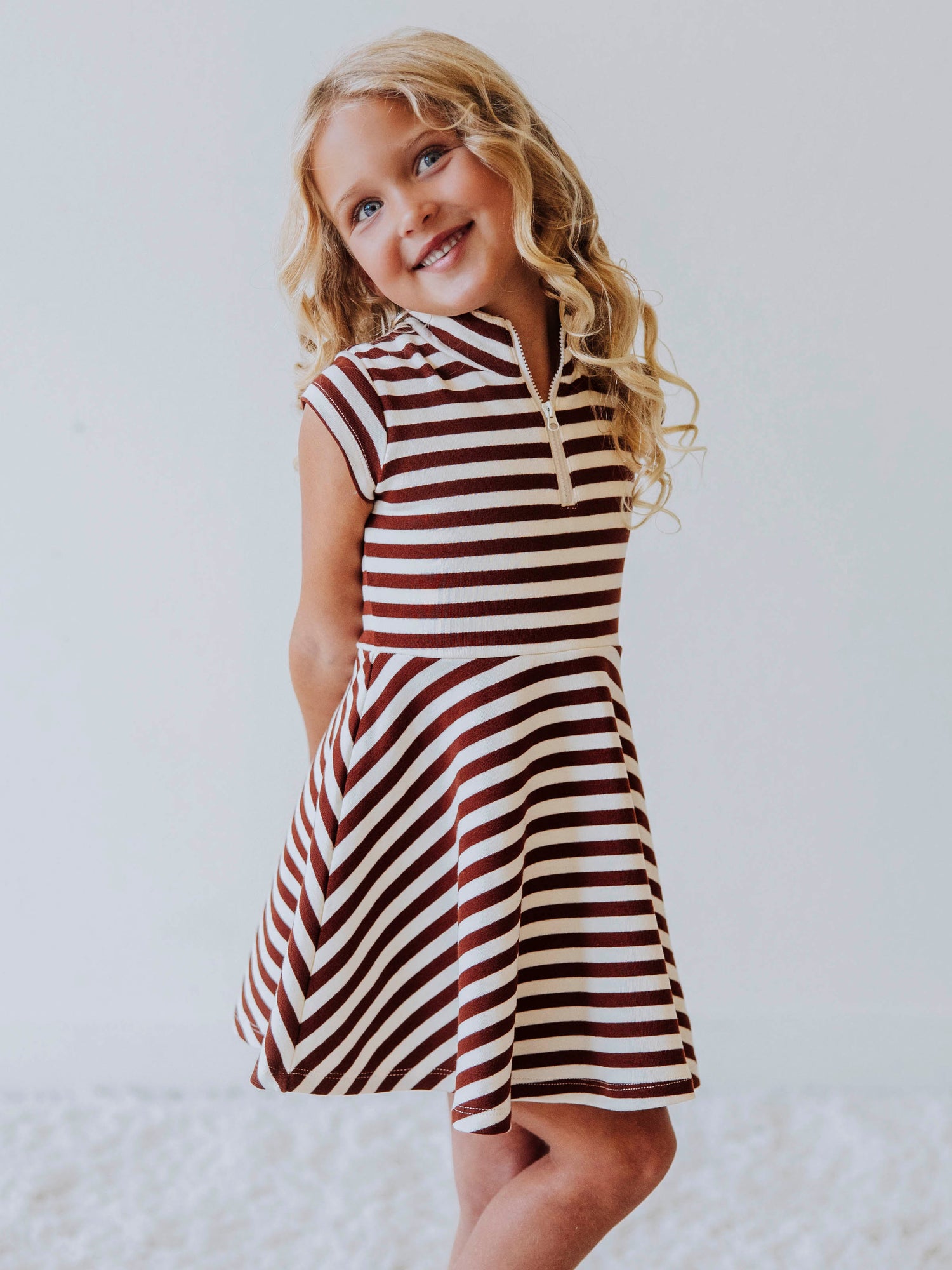 Model wearing a brown and ivory striped dress. Model is wearing brown shoes too. 