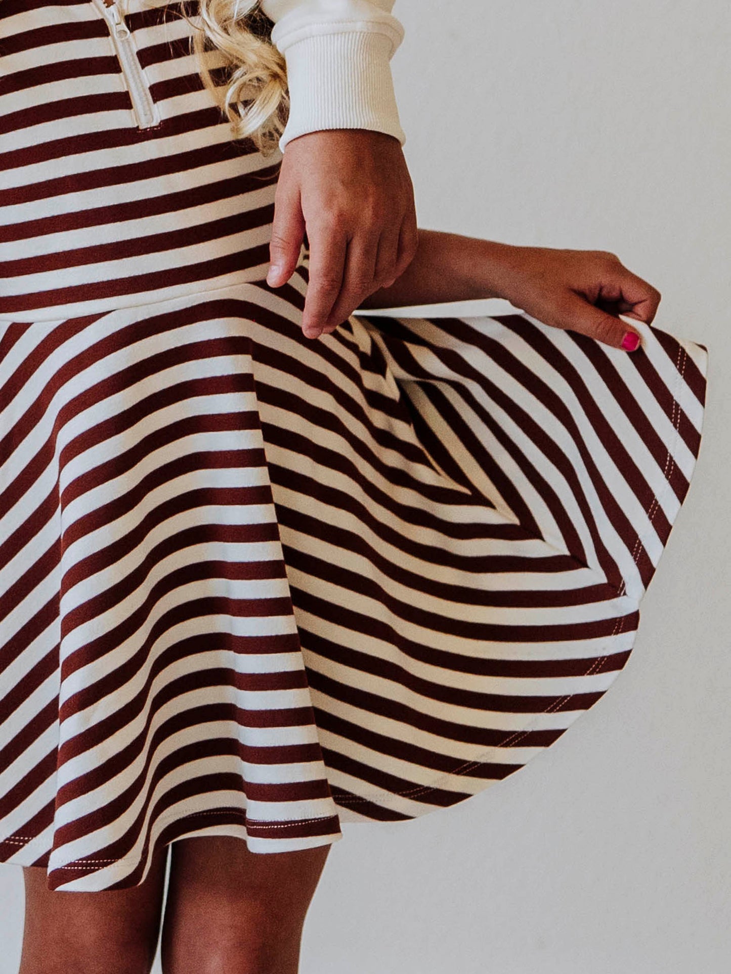 Model wearing a brown and ivory striped dress. 