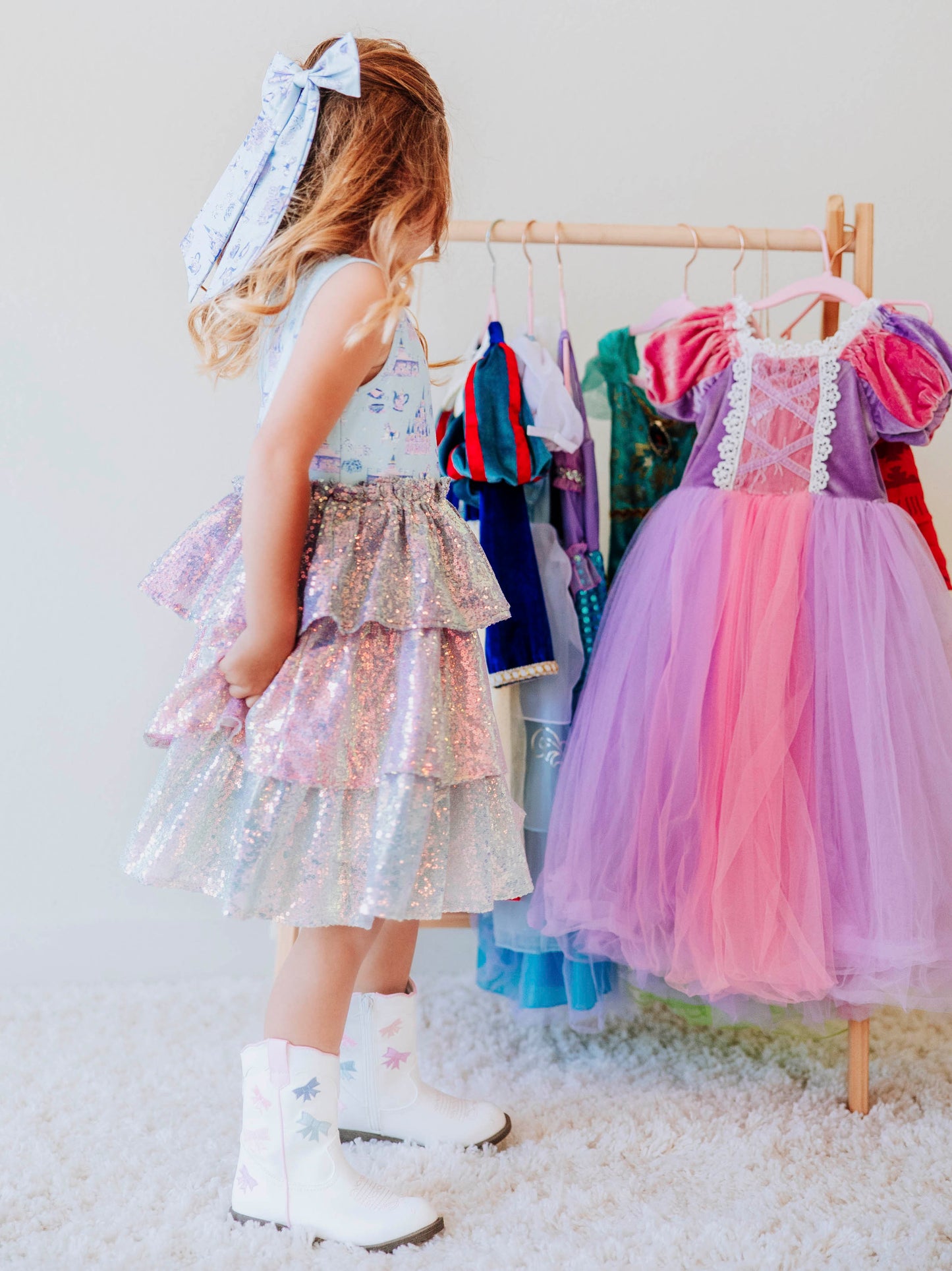 Make every day feel like a fairytale in our Most Magical Tiered Sparkle Dress! This enchanting girls’ dress features our signature “Most Magical” print bodice — filled with dreamy castles, carousels, and whimsical details — paired with a tiered iridescent sequin skirt that shimmers with every twirl. Designed for comfort and style, it’s perfect for holiday photos, birthday parties, or any moment that calls for a little extra sparkle. 