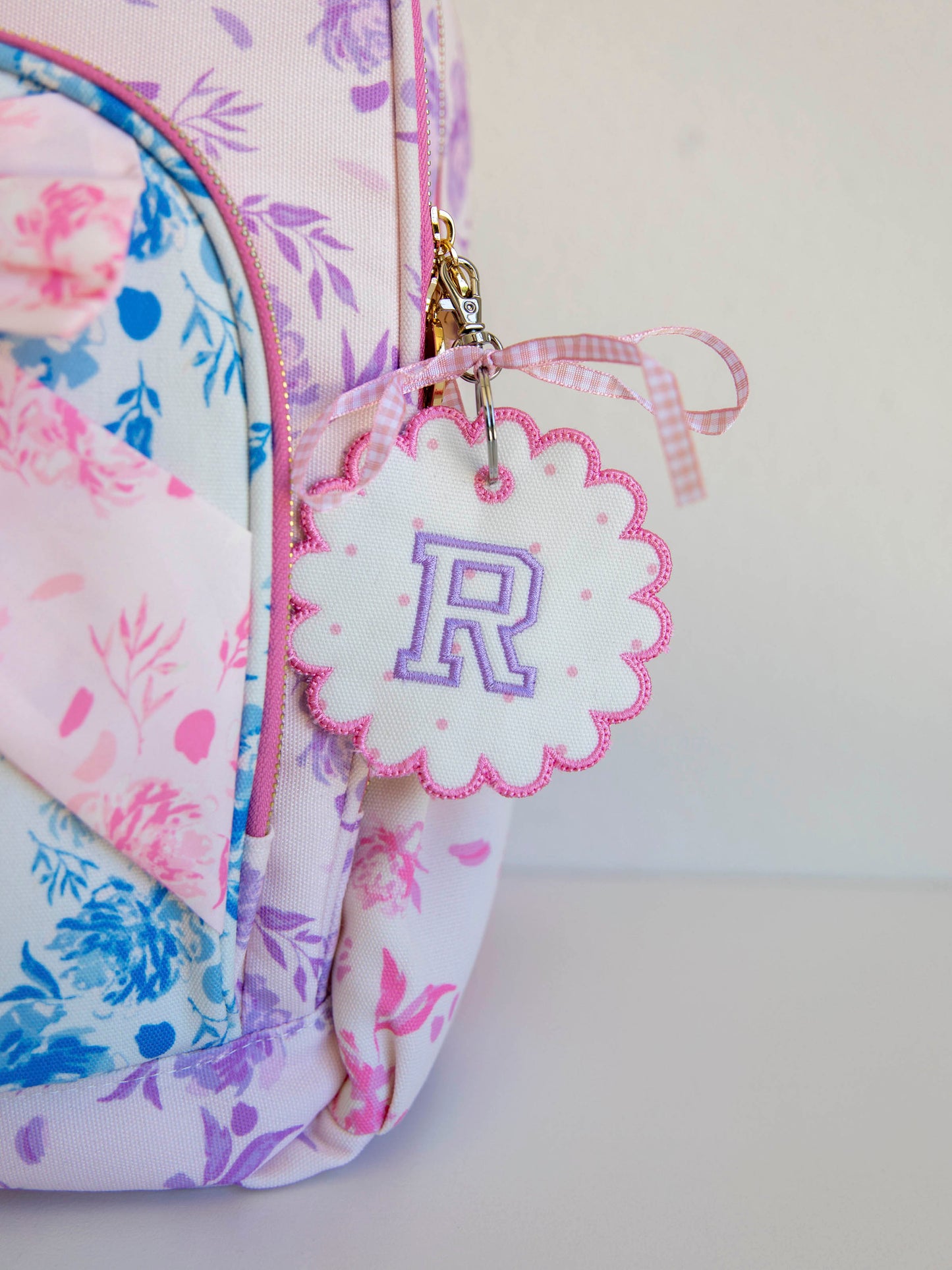 Backpack with a monogrammed tag with the letter R on it