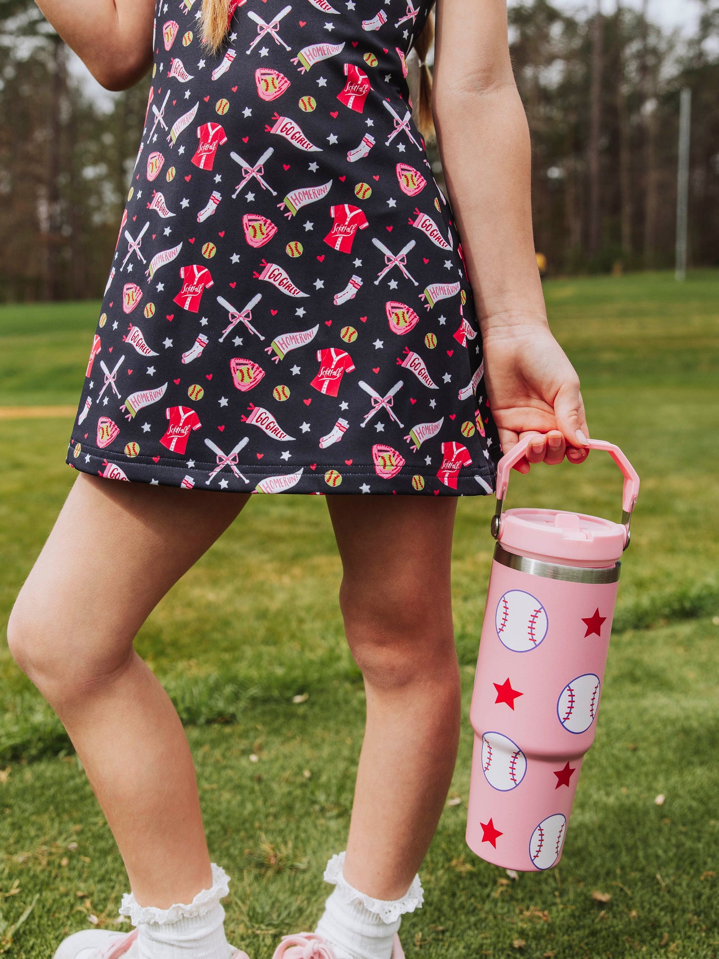 Girl holding a softball print water bottle with handle