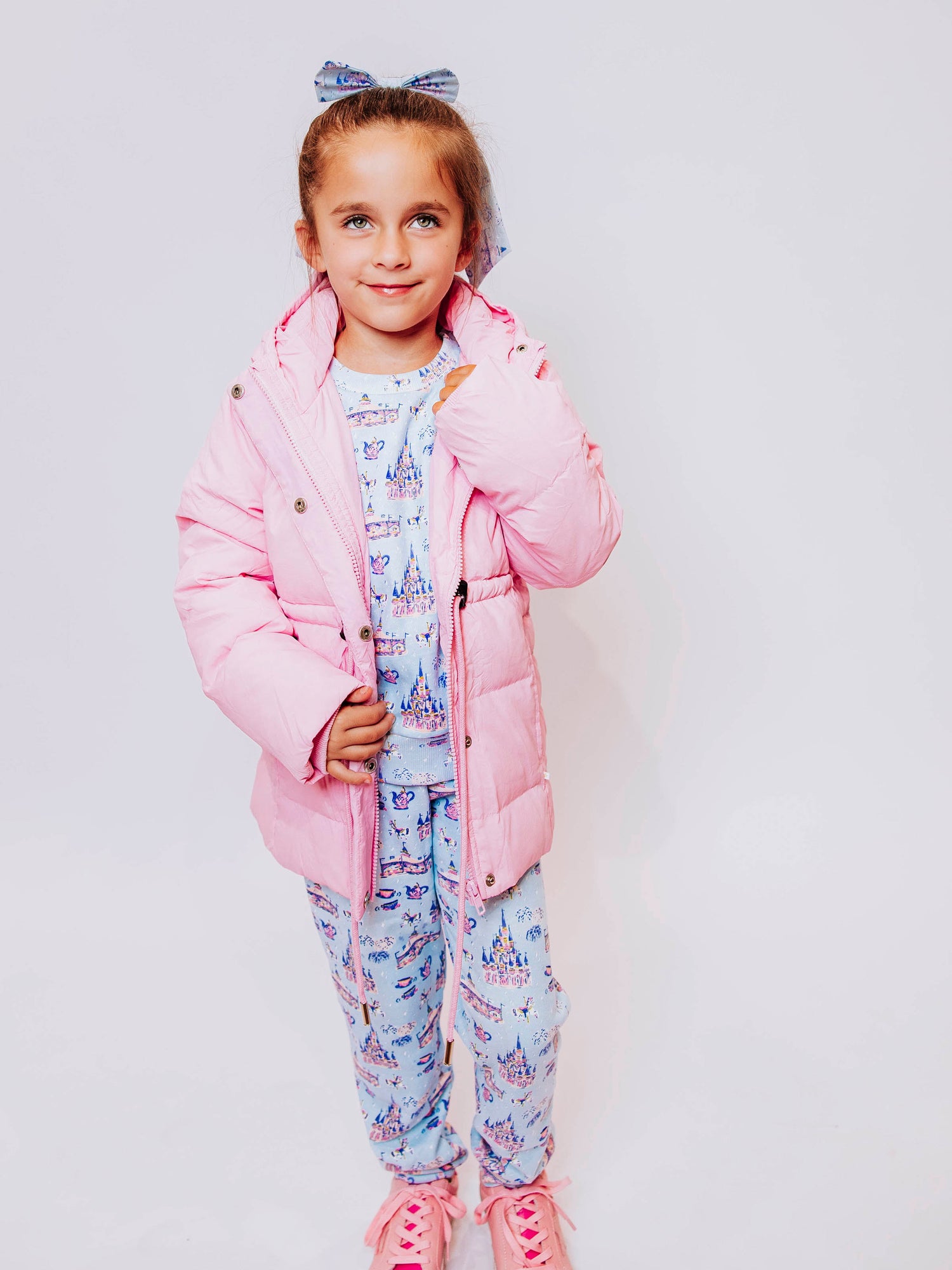 Keep her cozy and cute all season long in our Pink Puffer Jacket — the perfect blend of warmth and style! This soft, quilted jacket features a full zipper closure with a button placket, ensuring extra protection from chilly winds. Hidden front pockets keep little hands warm (or treasures tucked away), while the adjustable waist toggle allows for the perfect, comfortable fit. Designed in a beautiful blush pink hue, this girls’ puffer jacket pairs effortlessly with any winter outfit for a look that's fun!