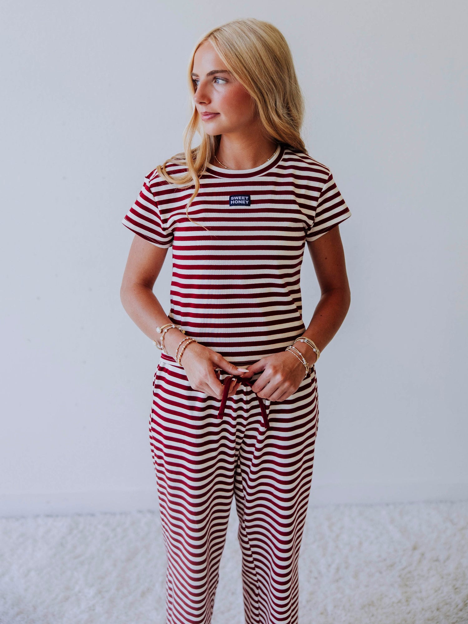 Model weraing a two-piece crimson and ivory pant set. 