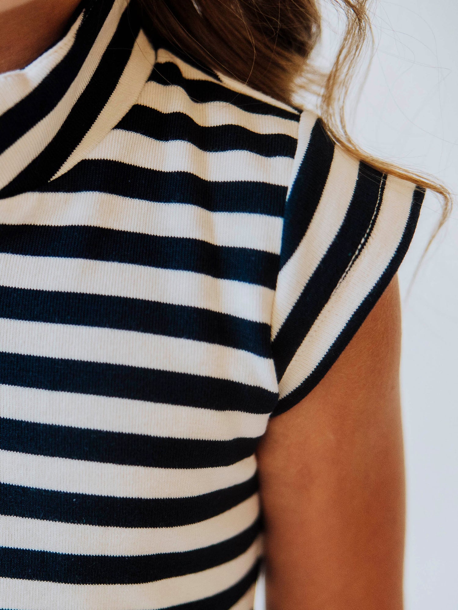 Close up of cap sleeve on ivory and navy stiped dress. 