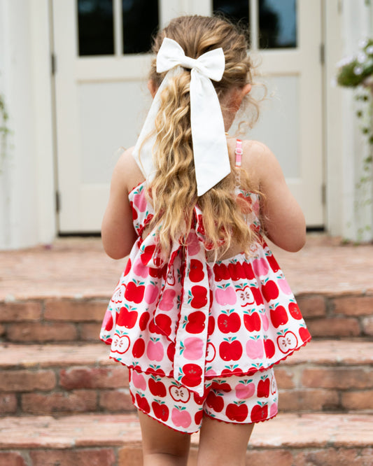 Backside of girl outside in two piece apple set with bow