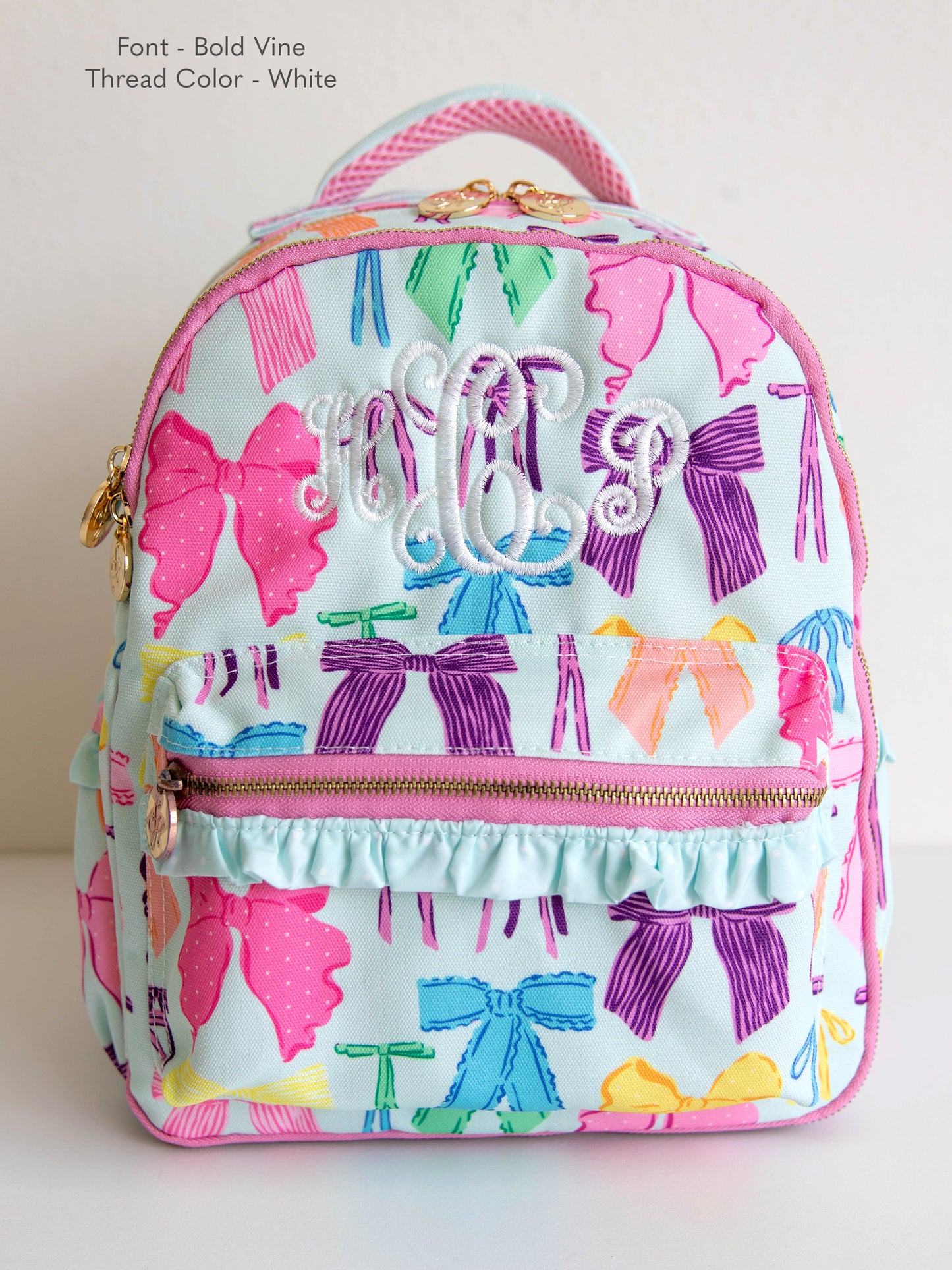 Vibrant bows printed backpack with customized embroidery, gold zippers and zipper pulls, and a handle