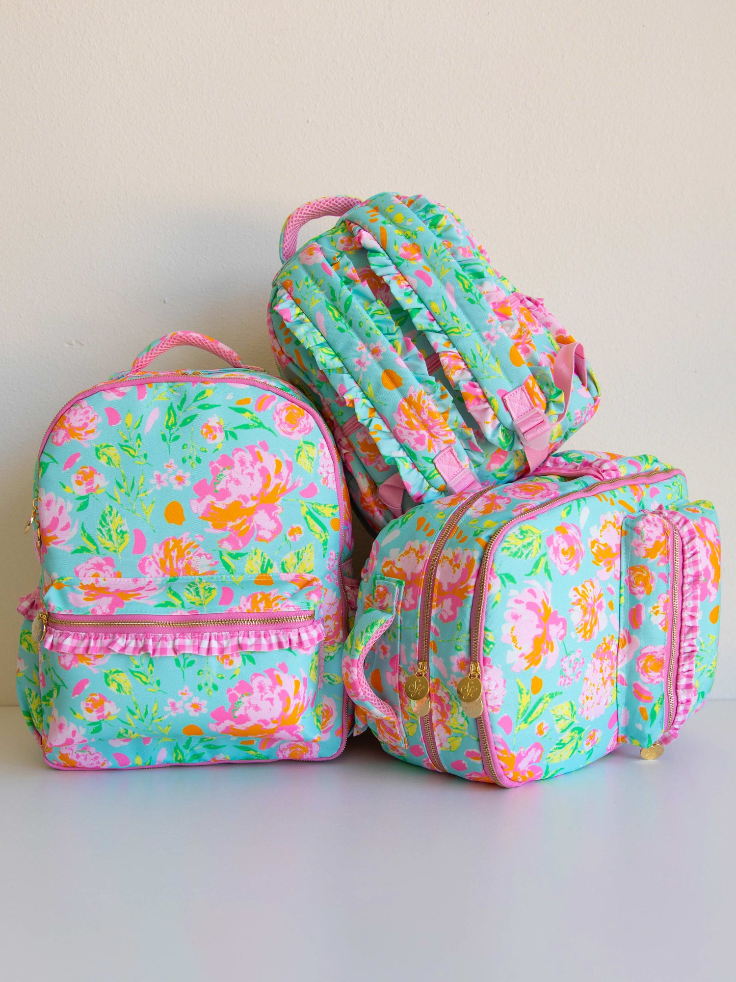 Three different sizes of colorful and floral backpacks
