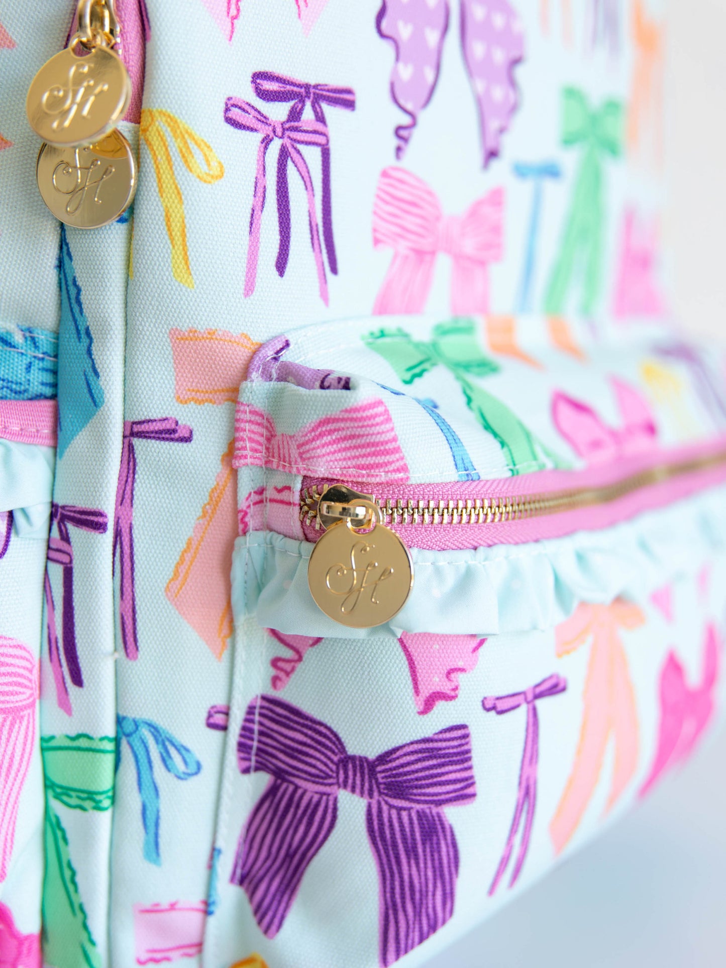 Vibrant bows printed backpack with  gold zippers and zipper pulls