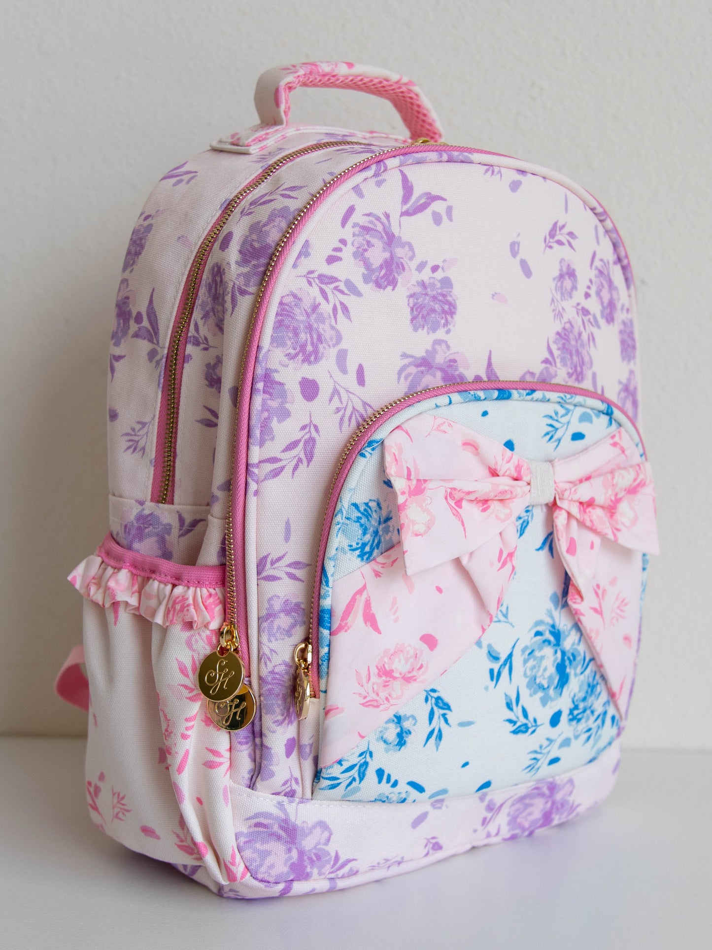 Backpack with floral prints and a bow on the front. 