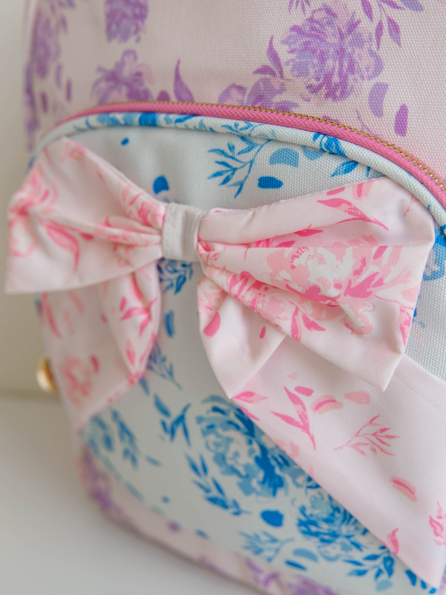 Backpack with floral prints and a bow on the front. Zoomed in pic of bow. 