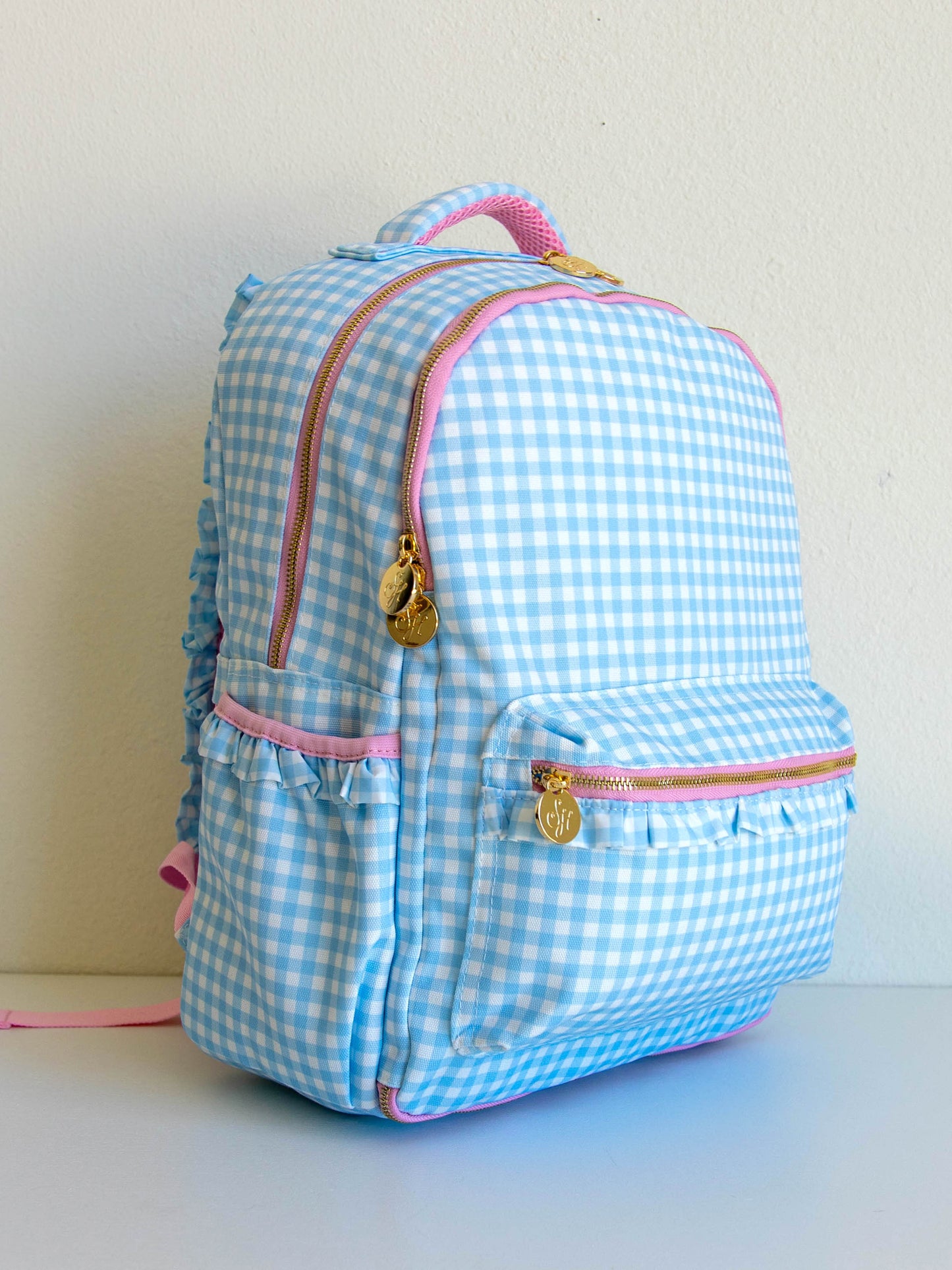 Blue gingham backpack with pink accents and gold zipper pulls