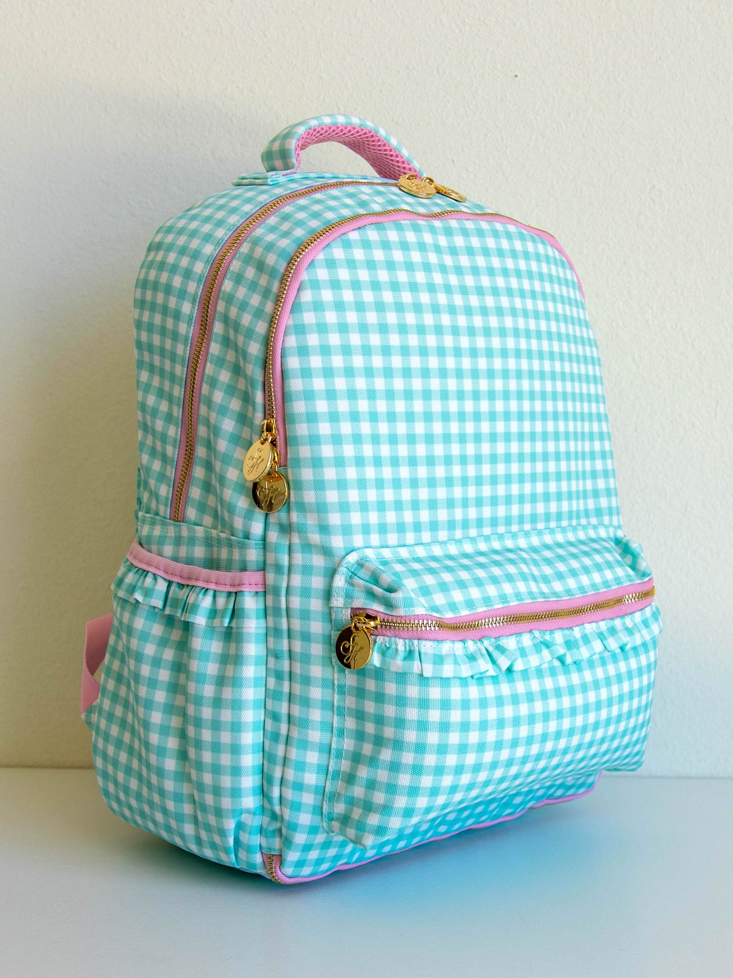 mint green gingham backpack with pink accents and gold zipper pulls