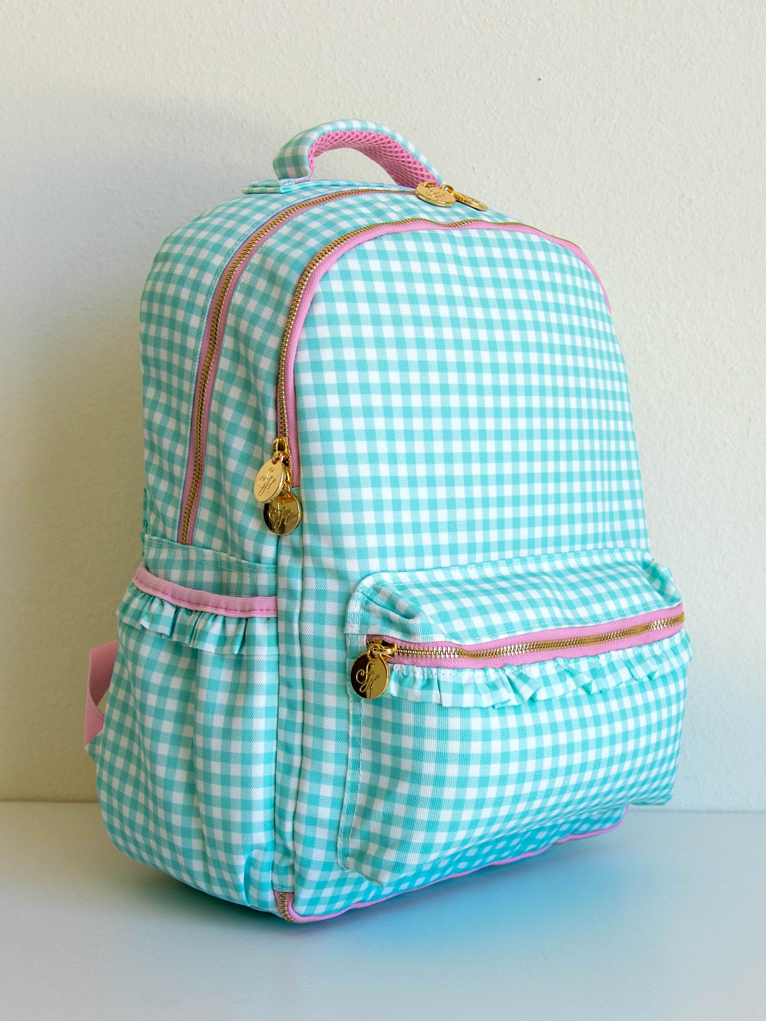 mint green gingham backpack with pink accents and gold zipper pulls