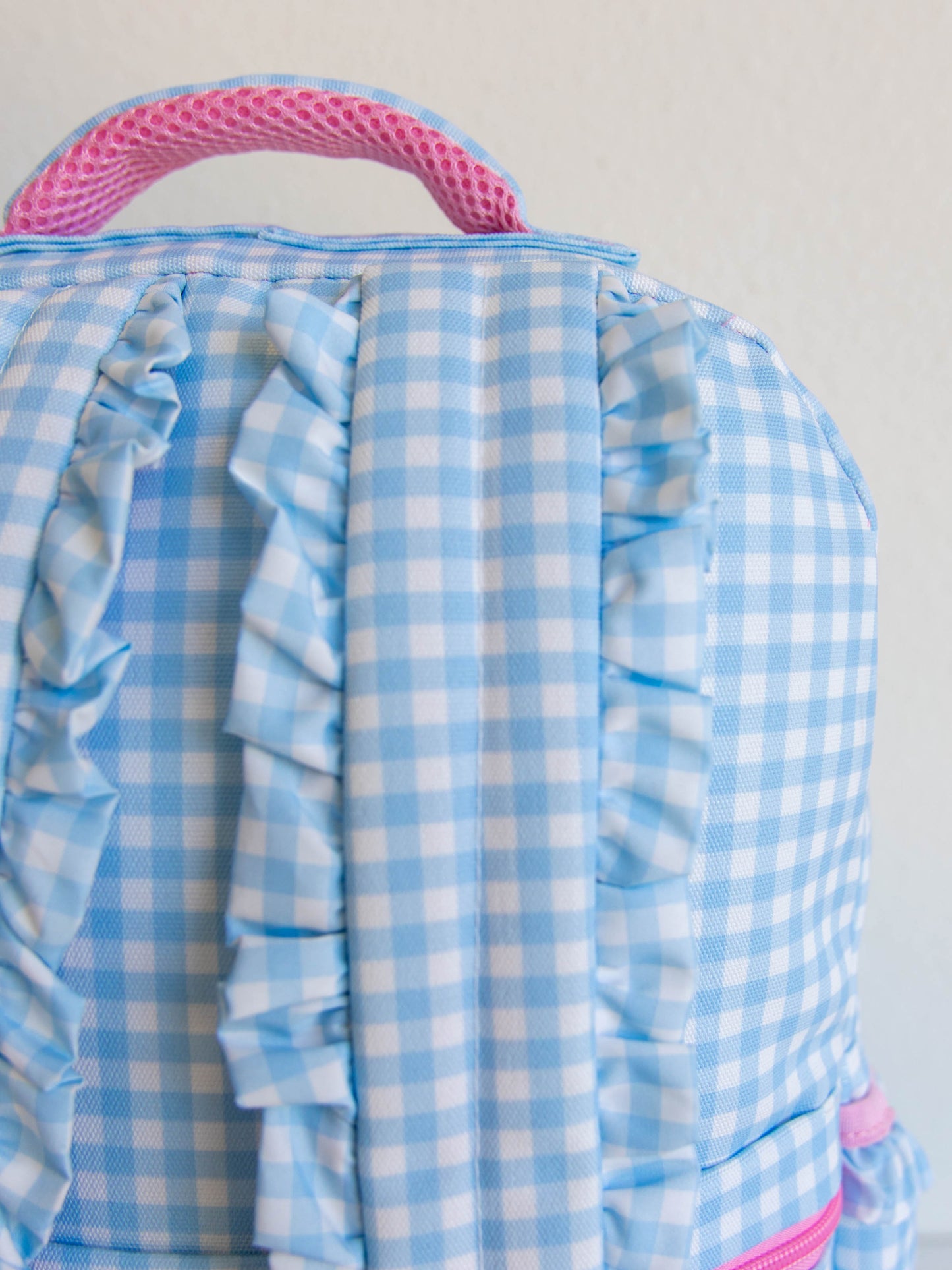 Blue gingham backpack with ruffled straps and top handle