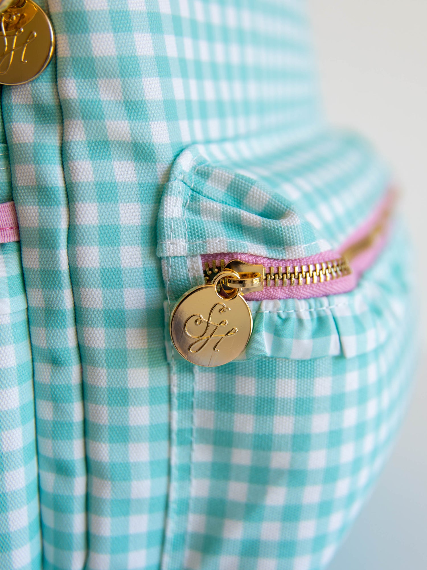 close up of gold, SH engraved zipper pull