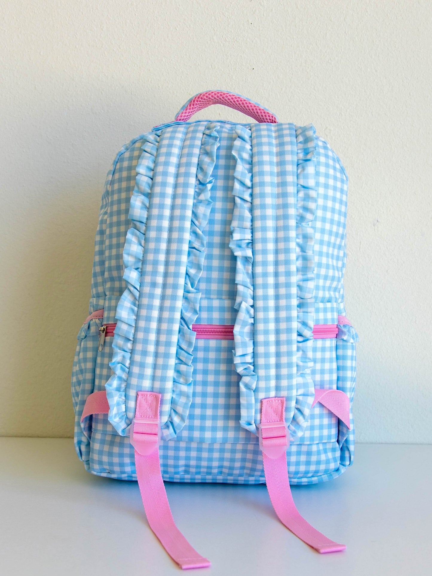 Backside of Blue Gingham backpack. Ruffled straps shown.