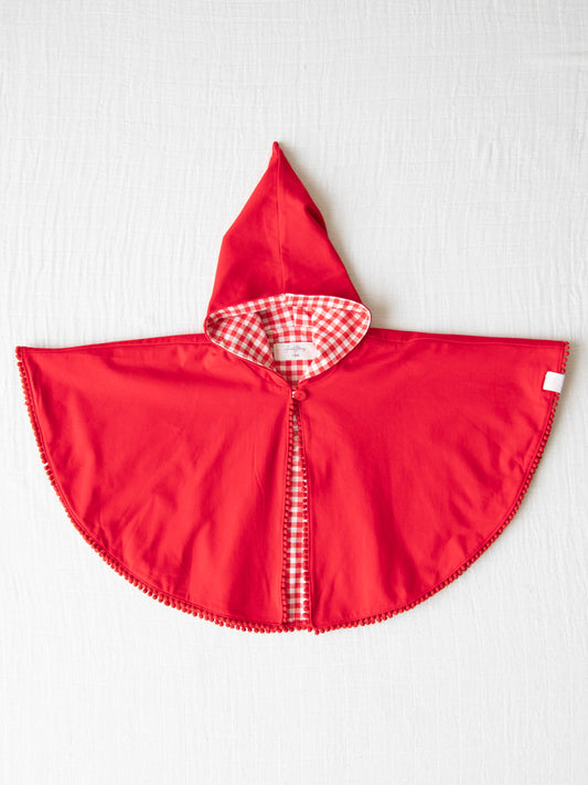 Little Red Riding Hood has never looked so good.  This short red cape has a solid red outside and a red check inside pattern.