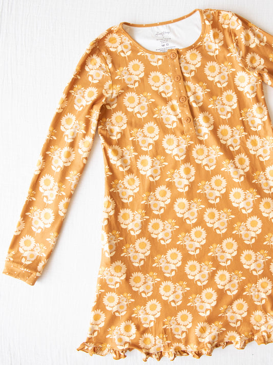 Women's Gown - Autumn Sunflowers. This long-sleeved gown comes in a pattern of tan sunflowers on a burnt orange background.