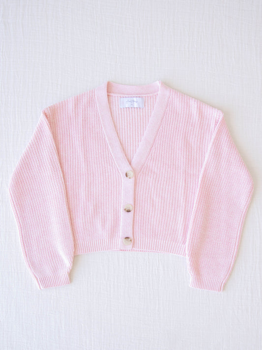 Classic Knit Cardigan – Sweetly Pink. This light pink ribbed knit cardigan has three functional buttons down the front.