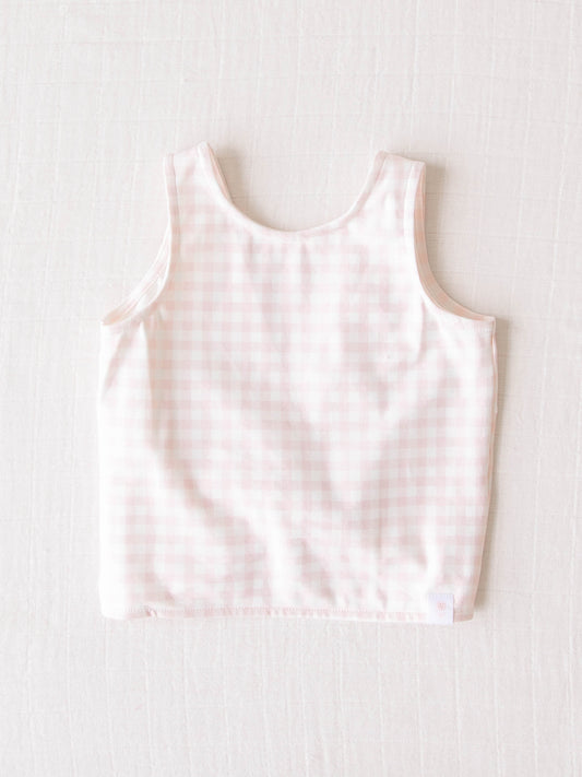 This twisted back top comes in a pattern of pale pink check.