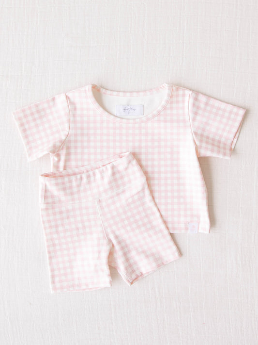 All in Motion Set – Pink Check. This activewear set of a shirt and shorts is a pattern of pale pink check.
