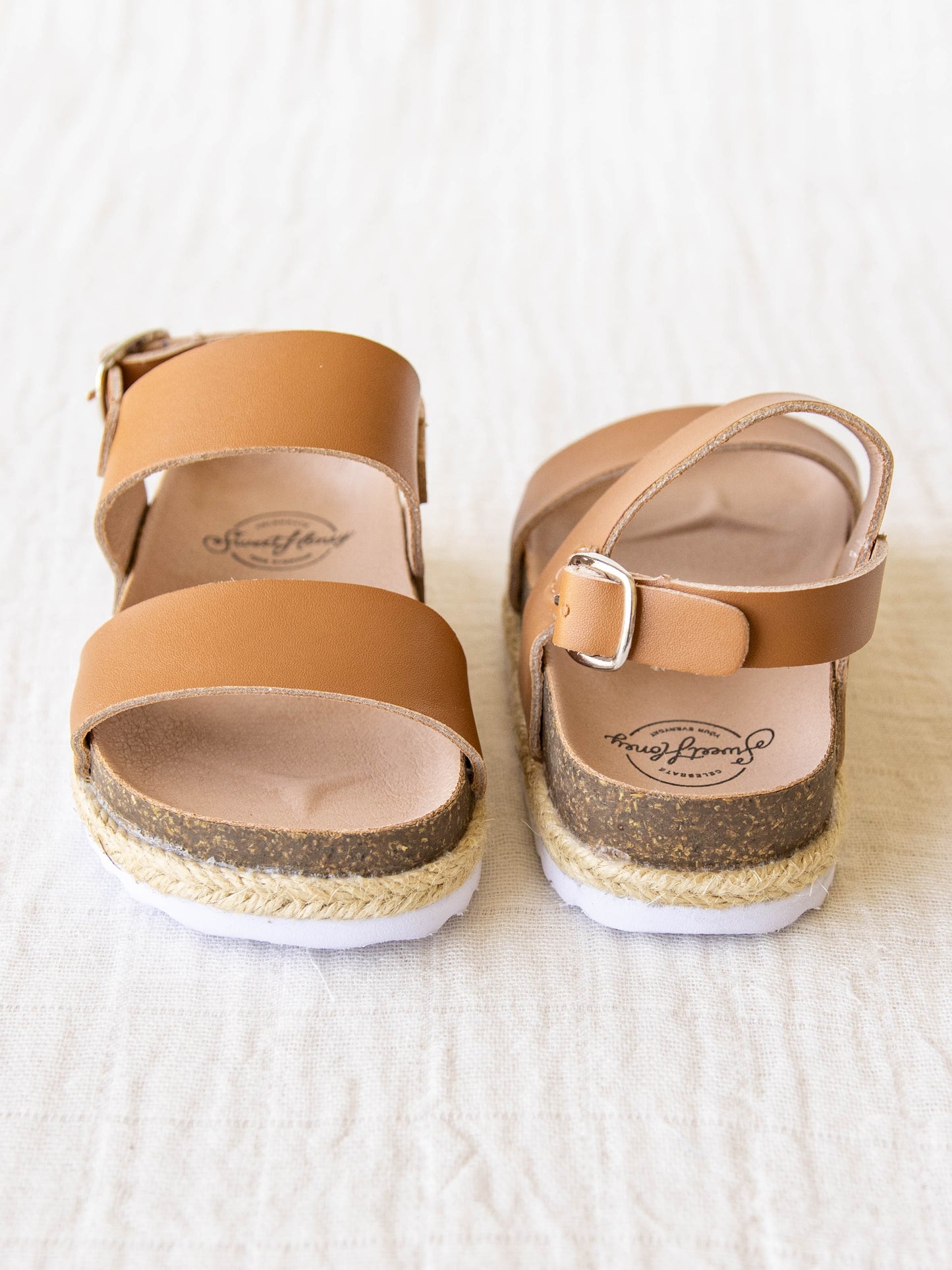 These Strappy Cork Sandals are made of wide strips of Brown manmade leather, cork sole, and have a metal adjustable buckle.