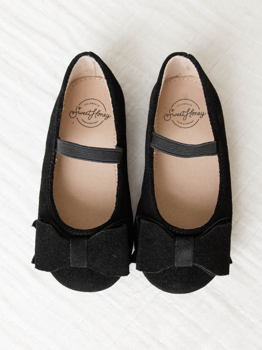 These Big Bow Suede Ballet shoe come in Black with an elastic strap across the top of the foot. The suede bows sit proudly on top of the shoes’ toe.