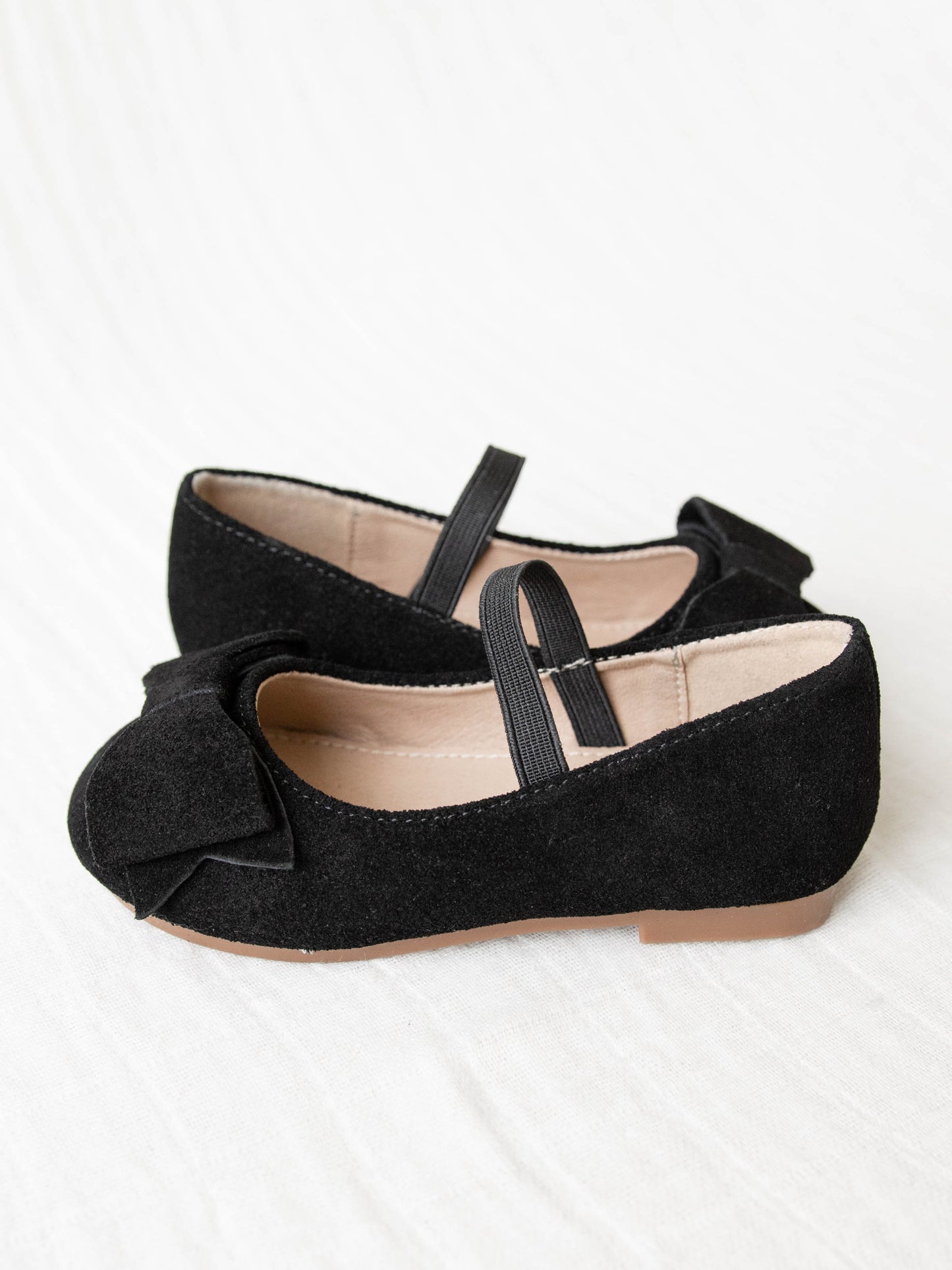 These Big Bow Suede Ballet shoe come in Black with an elastic strap across the top of the foot. The suede bows sit proudly on top of the shoes’ toe.