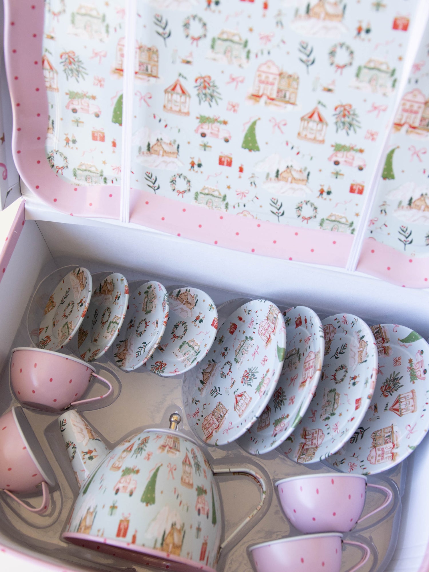 The serving tray, plates, and kettle features our pattern Christmas Village. The cups are a pattern of pink polka dots on light pink.