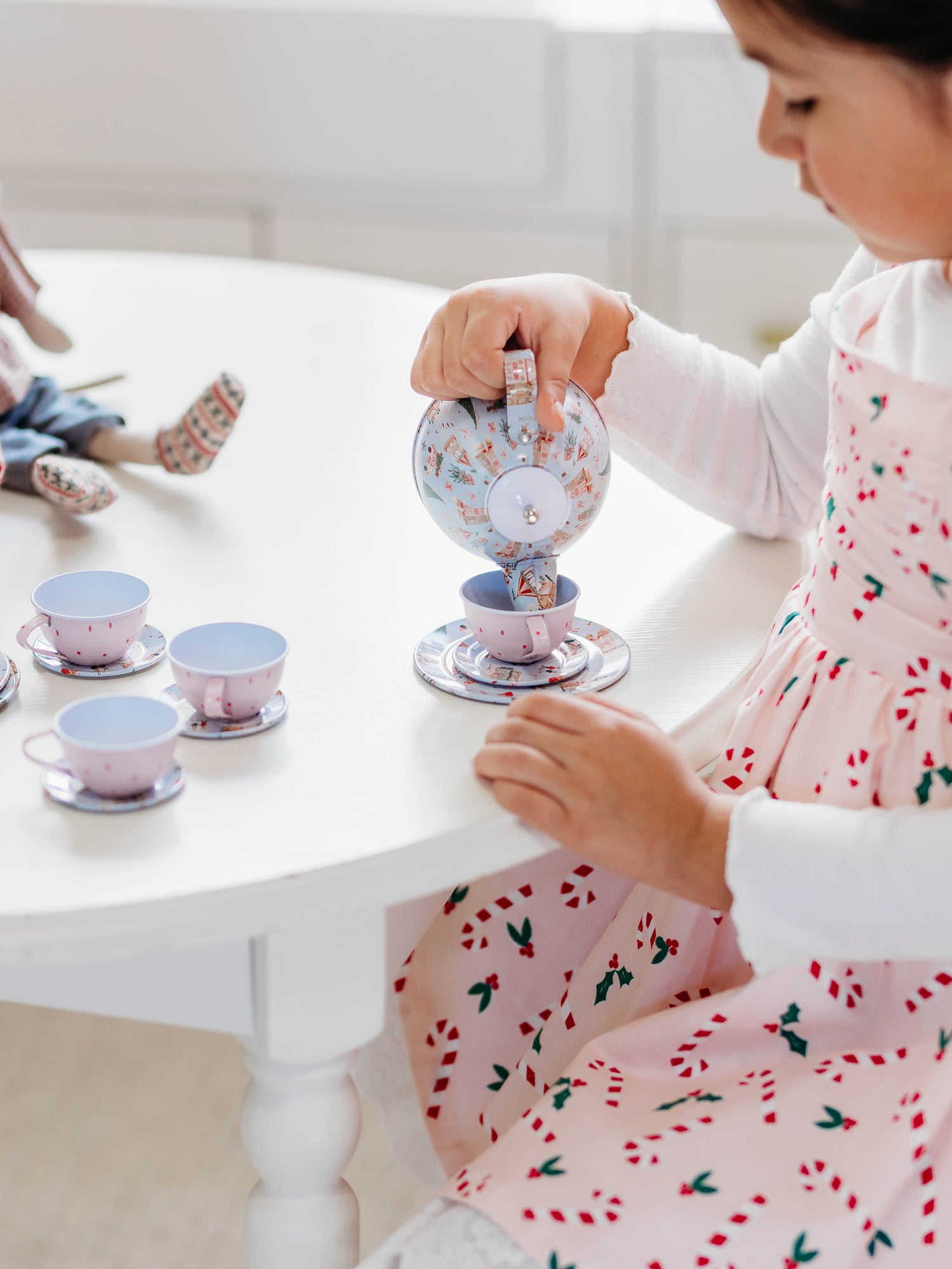 The serving tray, plates, and kettle features our pattern Christmas Village. The cups are a pattern of pink polka dots on light pink.