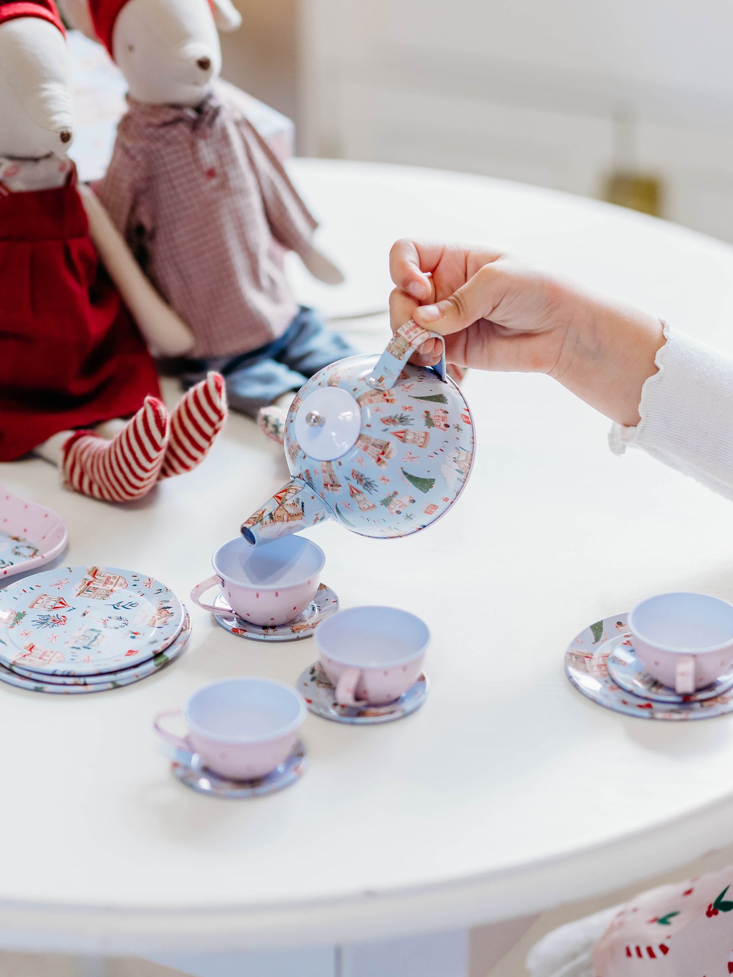 The serving tray, plates, and kettle features our pattern Christmas Village. The cups are a pattern of pink polka dots on light pink.